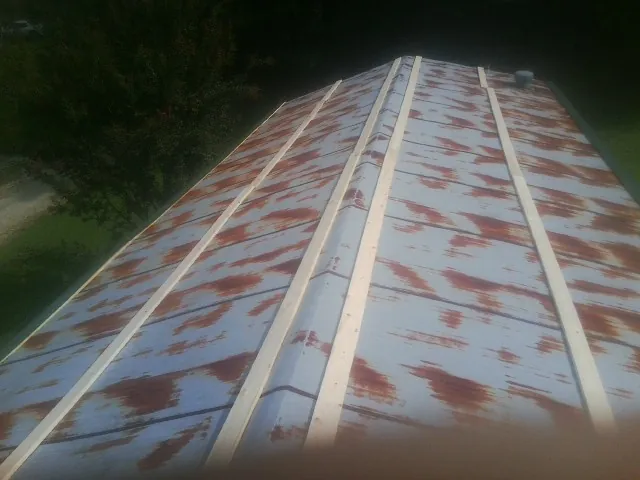 Rusted metal roof panels with new wood purlins before replacement — Storm Damage Roof Repair in Bellefonte by Roofing Brothers