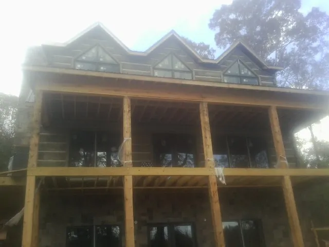 Dormers and porch framing on a large log home under construction — Roof Coating work by our crew in Bellefonte
