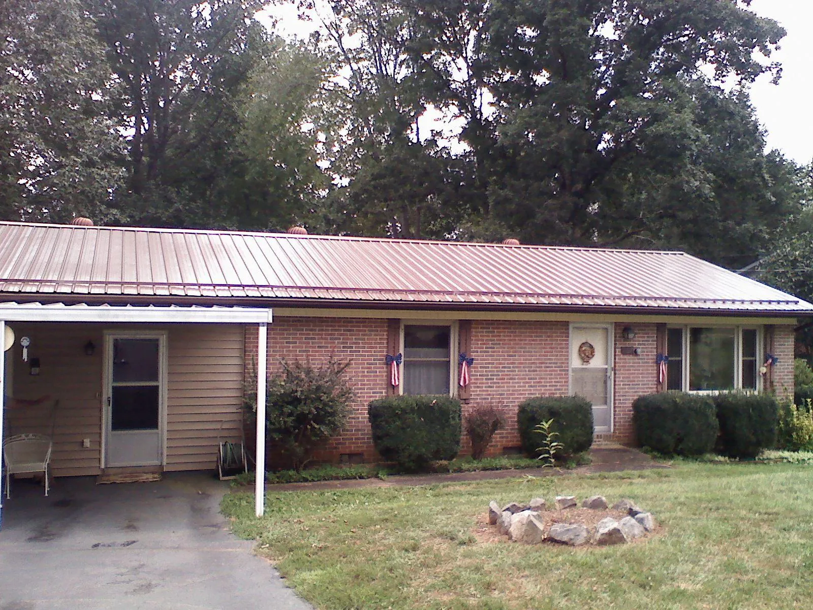 Bronze metal roof and carport on a brick ranch home — Roof Repair work by our crew in Bellefonte