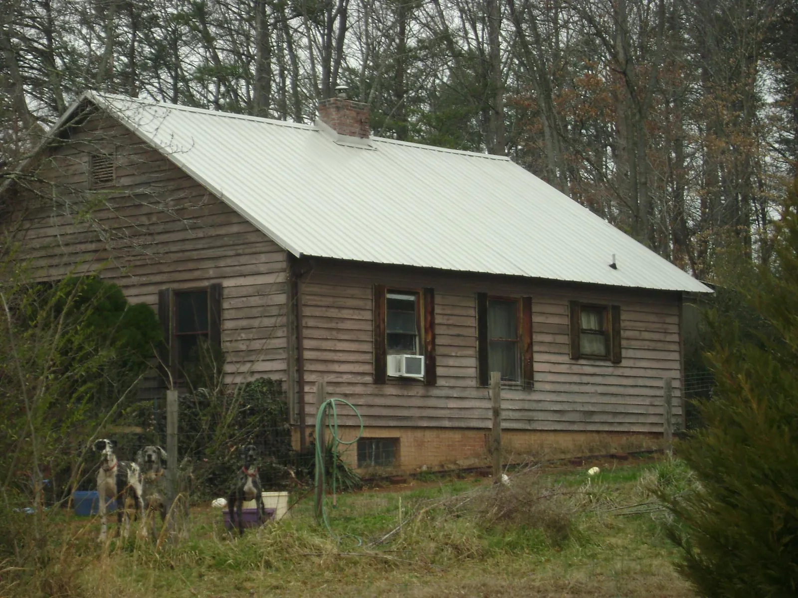 White metal roof on an old wood sided farmhouse, from a Metal Roof Installation job in Bellefonte